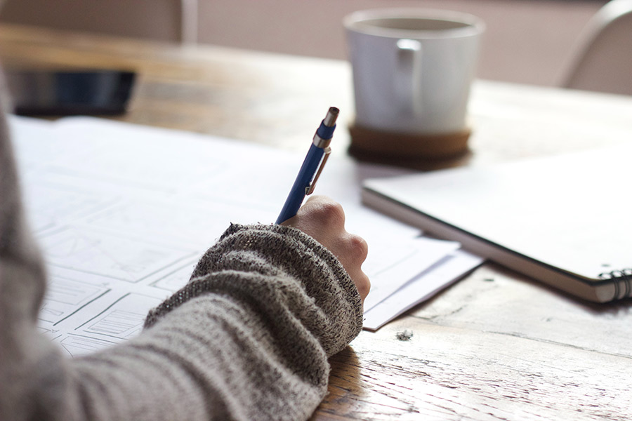 woman writing on sheets of paper